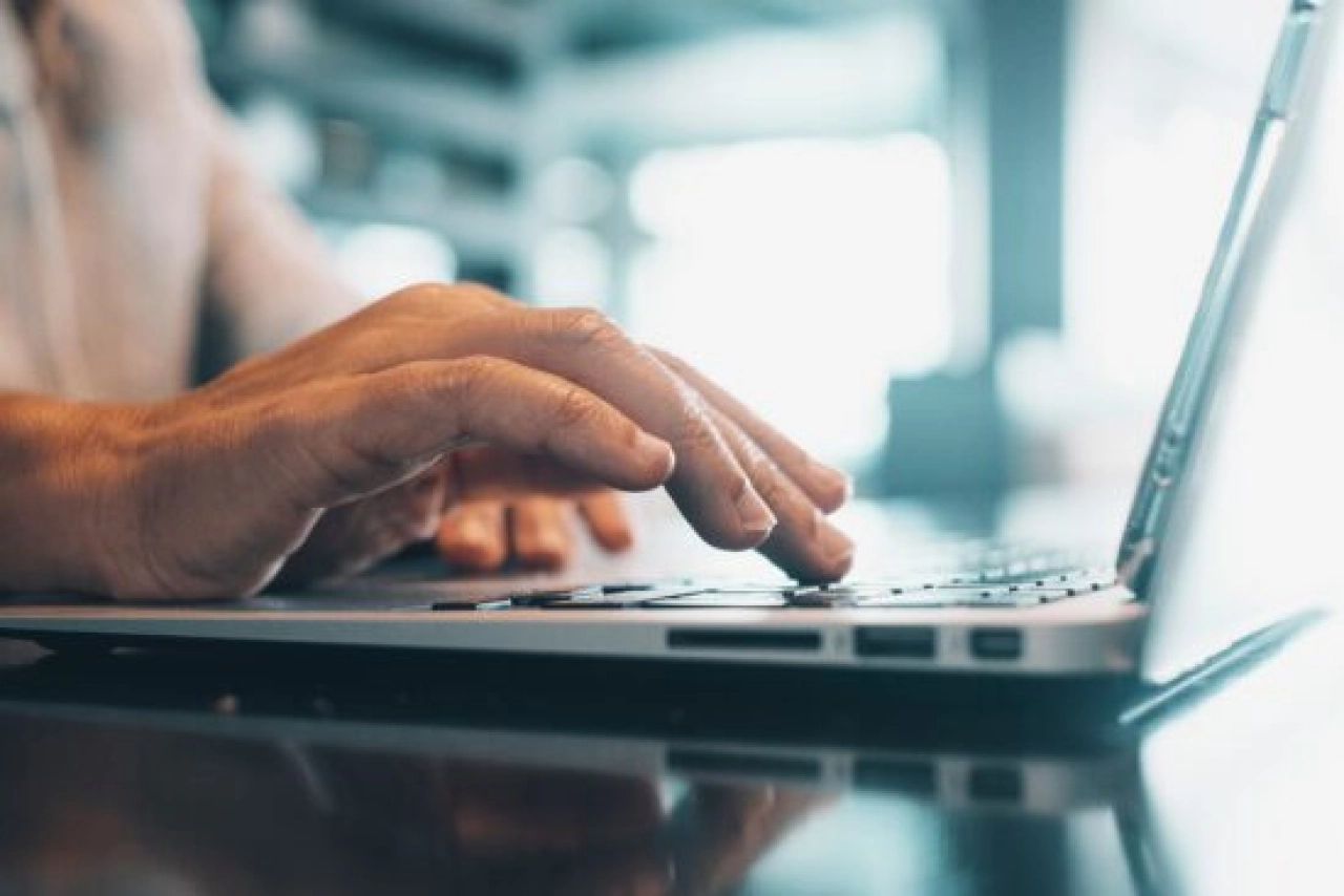 a person's hand on a laptop computer keyboard